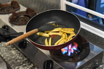 Bananas frying with whisky and syrup on a pan for mexican santa fe (caramelized banana)