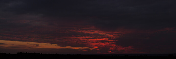 Purple-magenta clouds. Tragic gloomy sky. Landscape with bloody sunset. Fantastic skies on the planet earth. Twilight, nightfall. Blackout.