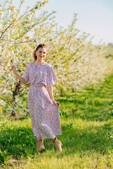 Fototapeta na wymiar an attractive brunette woman in a lilac in a spring flowering garden.