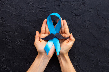 Awareness blue ribbon with a paper mustache. Symbol of prostate cancer