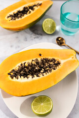 Ripe and freshly cut papaya with its seeds and white background. Fresh and tropical fruit