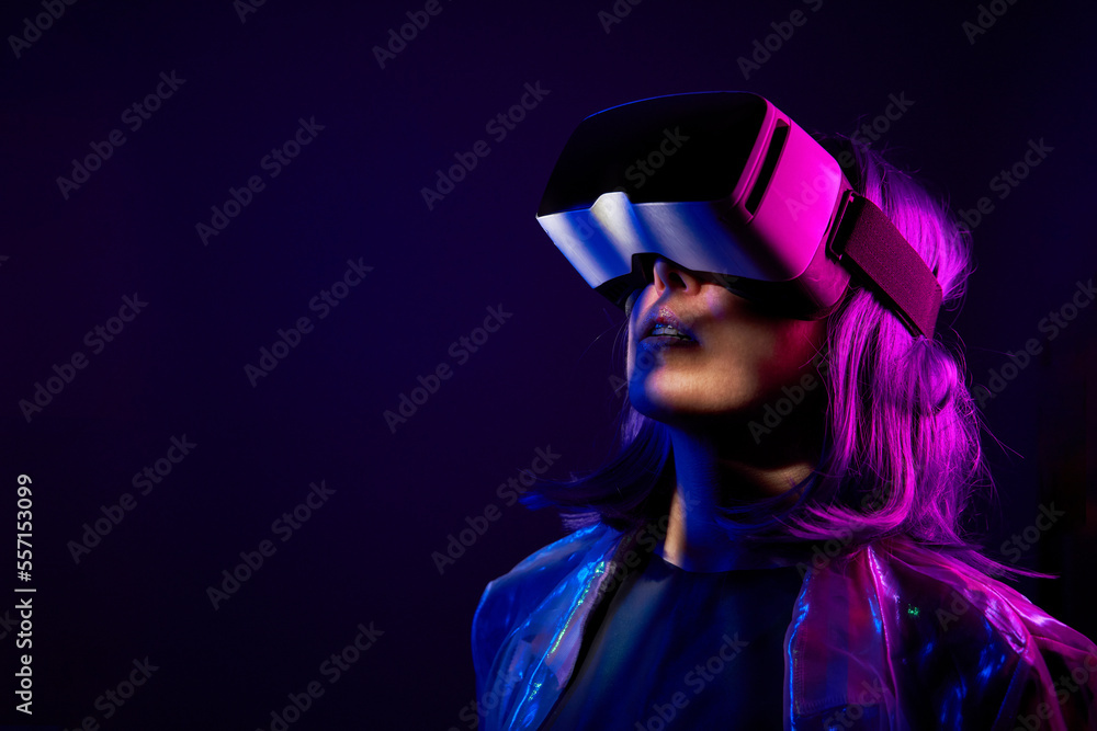 Wall mural Woman in virtual reality goggle in neon colors.