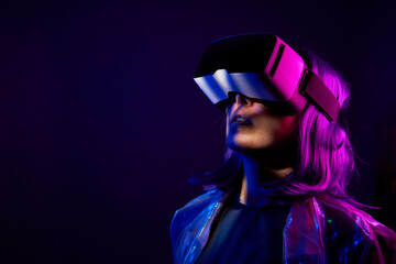 Woman in virtual reality goggle in neon colors.