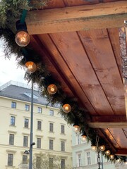 Edison style lightbulbs on christmas garland on a wooden gazebo at x-mas market in the city