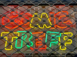 Window of a comics shop with neon sign glowing