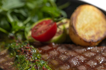 close-up of cooked steak with potatoes and vegetables
