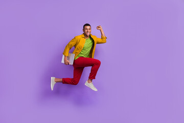 Fototapeta na wymiar Full body profile photo of crazy active person hold netbook jump hurry rush empty space isolated on violet color background