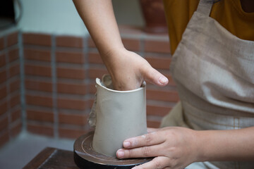 Hand close up of Young Asian female in the pottery workshop 