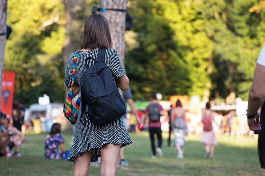 Young woman at outdoor summer festival carrying a backpack