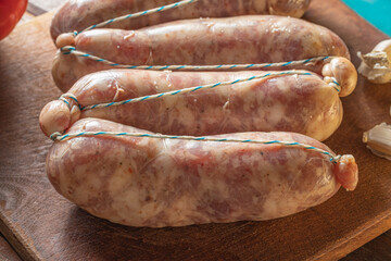 Close up of raw chorizos on a cuting board , typical Argentine sausages made with mixed pork and beef meat.