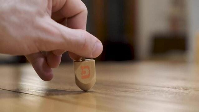 Dreidels sides and letters. Hand spinning three Hannuka dreidels - Sevivonim Jewish Dreidels spinning Close up. Jewish holiday traditions. Playing with toys sevivon