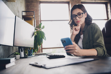 Photo of serious confident lady boss wear spectacles reading messages modern gadget indoors...