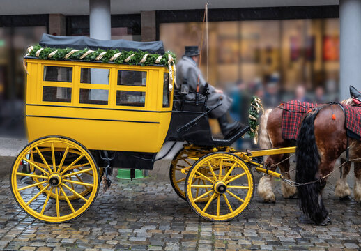 Historische gelbe Postkutsche von zwei Pferden gezogen in der Nürnberger Altstadt in der Vorweihnachtszeit	