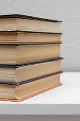 a stack of old books lies on the table.