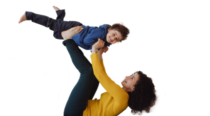 Boy likes to fly. Happy Italian mother older sister lying on back on white sofa having fun with little kid lifting excited child boy in air on outstretched legs. Curly mom play airplane with small son