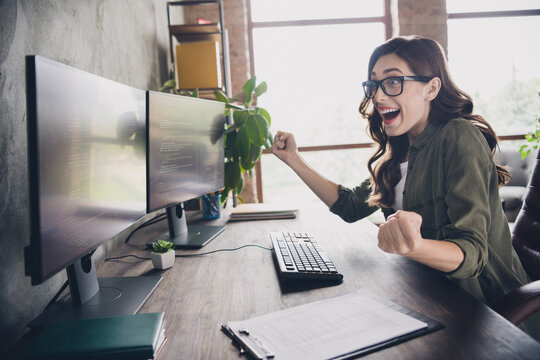Profile photo of delighted overjoyed hardware expert sit chair raise fists task accomplishment workstation indoors