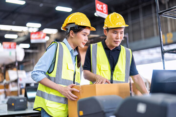 Staff working in large depot storage warehouse trainee check packing box and scan at cashier counter