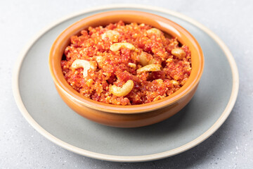 Gajar ka halwa is, Popular Indian dessert pudding made with grated carrots, milk, sugar and nuts served hot with a garnish of almonds, cashew nuts and pistachios.

