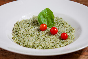 Risotto con pesto alla genovese, pomodori pachino e basilico. 