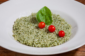 Risotto con pesto alla genovese, pomodori pachino e basilico. 
