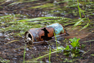 Pollution of our waters and the environment with a partially submerged rusty metal can, a clear example of why we should recycle