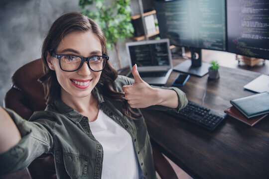 Photo of charming positive lady web designer developer thump up enjoy lovely work good results finish project indoor workstation