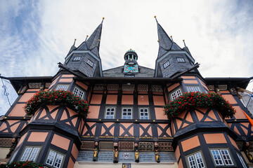 Wernigerode, Saxony-Anhalt, Germany, 29 October 2022:  Historic townhall or Rathaus in Market Square, vintage colored timber framed building Fachwerkbau, half-timbered home at sunny autumn day