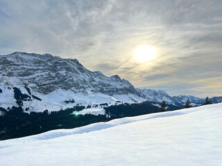 Late evening winter sun over the snow-covered slopes of the Alpstein mountain range and before dusk over massif of the Swiss Alps, Urnäsch (Urnaesch or Urnasch) - Canton of Appenzell, Switzerland