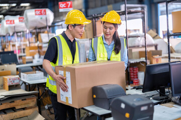 2 Staff working in large depot storage warehouse check packing box and scan at cashier counter