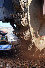 Bucket-wheel excavator during excavation at the surface mine. Huge excavator on open pit mine.	