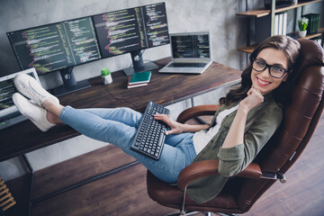 Photo of thoughtful smiling lady administrator wear spectacles writing code modern gadget indoors workplace workshop