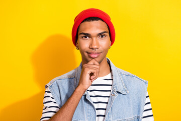 Portrait of creative clever person hand touch chin brainstorming red headwear isolated on yellow...