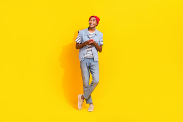 Fototapeta na wymiar Photo of dreamy charming guy dressed denim clothes empty space chatting instagram twitter isolated yellow color background