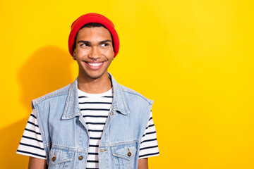 Portrait of cheerful satisfied young man beaming smile look interested empty space isolated on yellow color background