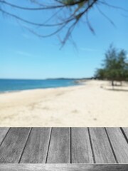 Wooden desk table top and blur tropical beach nature of the background illustration 