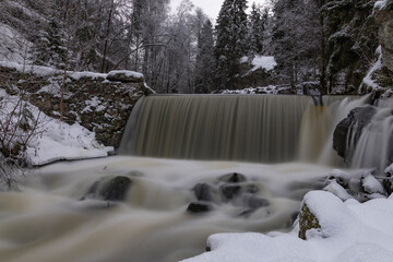 Waterfall in frosty winter landscape. Long exposure