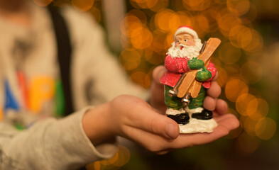 Statuette of Santa Claus in children's hands