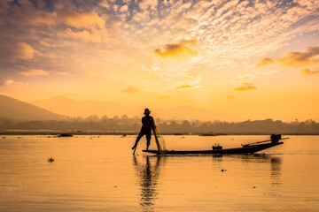 Myanmar travel attraction landmark - traditional Burmese fisherman sihouettes at Inle lake on...
