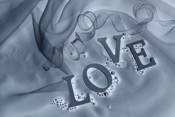 "LOVE"の文字と真珠とリボンとオーガンジーの背景（ブルーグレー）