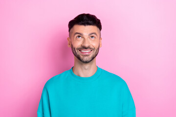 Photo of young cheerful smile positive man wear blue sweatshirt bristle beard look up interested...