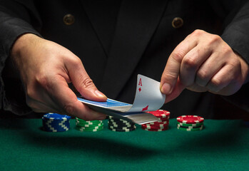 A card sharper pulls an ace of diamonds from a deck of playing cards while playing poker. The...