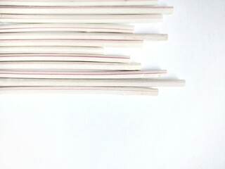 stack of white plastic straws over white background