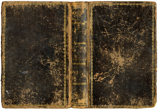 Antique open book with worn textured grungy leather cover and embossed abstract golden decorations, circa 1865