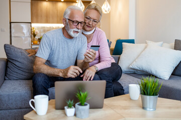 Senior couple using laptop at home