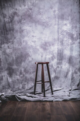 Drewniany stołek na szarym tle w studio - obrazy, fototapety, plakaty