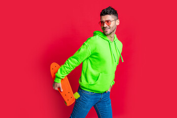 Happy skater isolated on red. Happy man skater holding pennyboard. Pennyboard skater © be free