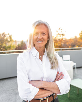 Smiling senior businesswoman standing on terrace