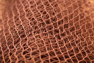 Brown fishing net, on soft brown background