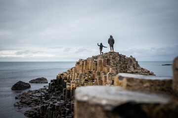 brother and sister climbing the rocks of the Giants Causeway in Northern Ireland