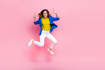 Fototapeta na wymiar Full size portrait of pretty cheerful girl jumping arms palms waving hi empty space isolated on pink color background